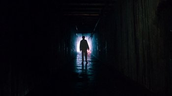 Movie still from “A Nightmare on Elm Street 3: Dream Warriors” (1987), directed by Chuck Russell – A person is walking in a dark tunnel; Wide shot, Low angle