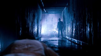 Movie still from “A Nightmare on Elm Street 3: Dream Warriors” (1987), directed by Chuck Russell – A man standing in a dark room with a bicycle; Wide shot, Low angle