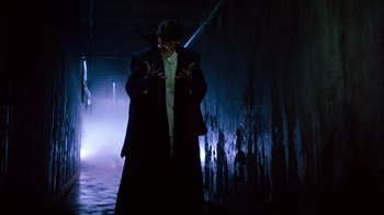 Movie still from “A Nightmare on Elm Street 3: Dream Warriors” (1987), directed by Chuck Russell – A man in a suit and mask standing in a dark room; Medium shot, Low angle