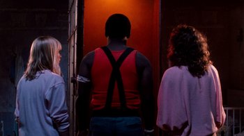 Movie still from “A Nightmare on Elm Street 3: Dream Warriors” (1987), directed by Chuck Russell – A man in a red tank top standing next to two other women; Medium shot, Over the shoulder angle