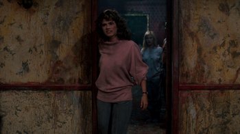 Movie still from “A Nightmare on Elm Street 3: Dream Warriors” (1987), directed by Chuck Russell – A woman standing in front of a door while another woman walks by in the background; Medium shot, Over the shoulder angle