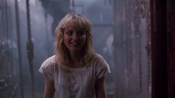 Movie still from “A Nightmare on Elm Street 4: The Dream Master” (1988), directed by Renny Harlin – A woman in white shirt standing next to a wall; Medium shot, Over the shoulder angle