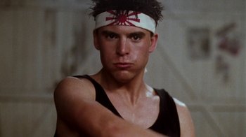 Movie still from “A Nightmare on Elm Street 4: The Dream Master” (1988), directed by Renny Harlin – A man with a headband is posing for a picture; Close Up shot, Low angle