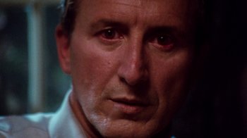 Movie still from “A Nightmare on Elm Street 4: The Dream Master” (1988), directed by Renny Harlin – A man's face in a dimly - lit room; Extreme Close Up shot, Low angle