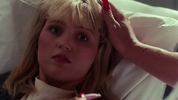 Movie still from “A Nightmare on Elm Street 4: The Dream Master” (1988), directed by Renny Harlin – A young girl is laying in bed with a red candle in her hand; Close Up shot, High angle