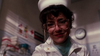 Movie still from “A Nightmare on Elm Street 4: The Dream Master” (1988), directed by Renny Harlin – A woman in a nurse's uniform wearing glasses and a hat; Close Up shot, Low angle