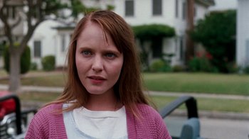 Movie still from “A Nightmare on Elm Street 4: The Dream Master” (1988), directed by Renny Harlin – A woman with red hair wearing a white shirt and a pink sweater; Close Up shot, Low angle