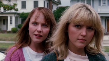 Movie still from “A Nightmare on Elm Street 4: The Dream Master” (1988), directed by Renny Harlin – Two women standing next to each other in front of a house; Close Up shot, Low angle