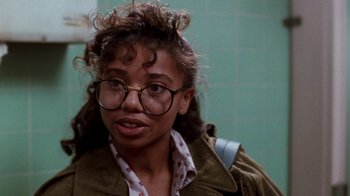 Movie still from “A Nightmare on Elm Street 4: The Dream Master” (1988), directed by Renny Harlin – A young woman wearing glasses and a brown jacket; Close Up shot, Over the shoulder angle