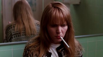 Movie still from “A Nightmare on Elm Street 4: The Dream Master” (1988), directed by Renny Harlin – A woman smoking a cigarette while sitting in a room; Close Up shot, Low angle