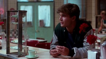 Movie still from “A Nightmare on Elm Street 4: The Dream Master” (1988), directed by Renny Harlin – A man sitting at a table with a cup of coffee in front of him; Medium shot, Over the shoulder angle