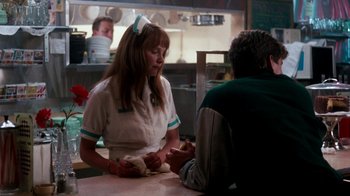 Movie still from “A Nightmare on Elm Street 4: The Dream Master” (1988), directed by Renny Harlin – A woman wearing a nurse's uniform is serving a man in a restaurant; Medium shot, Over the shoulder angle