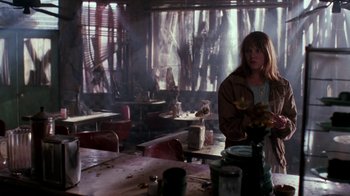 Movie still from “A Nightmare on Elm Street 4: The Dream Master” (1988), directed by Renny Harlin – A woman standing at a table in an abandoned restaurant; Medium shot, Over the shoulder angle