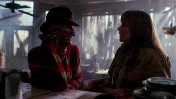 Movie still from “A Nightmare on Elm Street 4: The Dream Master” (1988), directed by Renny Harlin – A woman talking to an old man in a room; Medium shot, Over the shoulder angle