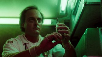 Movie still from “A Nightmare on Elm Street 4: The Dream Master” (1988), directed by Renny Harlin – A man holding a syringe in his hand; Close Up shot, Low angle