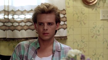 Movie still from “A Nightmare on Elm Street 2: Freddy's Revenge” (1985), directed by Jack Sholder – A young man in a plaid shirt looks at the camera; Close Up shot, Over the shoulder angle