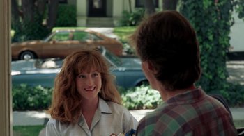 Movie still from “A Nightmare on Elm Street 2: Freddy's Revenge” (1985), directed by Jack Sholder – A woman is talking to a man in a plaid shirt; Medium shot, Over the shoulder angle