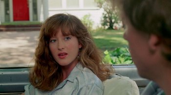 Movie still from “A Nightmare on Elm Street 2: Freddy's Revenge” (1985), directed by Jack Sholder – A woman sitting in the back seat of a car; Close Up shot, Over the shoulder angle