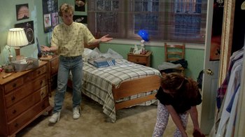 Movie still from “A Nightmare on Elm Street 2: Freddy's Revenge” (1985), directed by Jack Sholder – A man and a girl playing frisbee in a bedroom; Wide shot, High angle