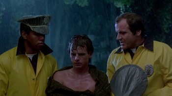 Movie still from “A Nightmare on Elm Street 2: Freddy's Revenge” (1985), directed by Jack Sholder – A group of men standing next to each other in the rain; Medium shot, Over the shoulder angle