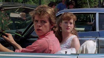 Movie still from “A Nightmare on Elm Street 2: Freddy's Revenge” (1985), directed by Jack Sholder – A man and a woman sitting in the back of a car; Close Up shot, Over the shoulder angle