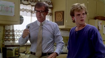 Movie still from “A Nightmare on Elm Street 2: Freddy's Revenge” (1985), directed by Jack Sholder – A man and a young boy playing a video game together; Close Up shot, Over the shoulder angle