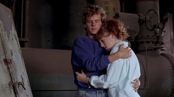 Movie still from “A Nightmare on Elm Street 2: Freddy's Revenge” (1985), directed by Jack Sholder – A man and a woman embracing each other; Medium shot, Over the shoulder angle