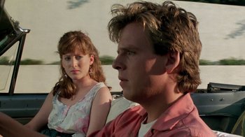 Movie still from “A Nightmare on Elm Street 2: Freddy's Revenge” (1985), directed by Jack Sholder – A man and a woman sitting next to each other in a car; Close Up shot, Over the shoulder angle