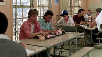 Movie still from “A Nightmare on Elm Street 2: Freddy's Revenge” (1985), directed by Jack Sholder – A group of people sitting at a table eating pizza; Medium shot, High angle