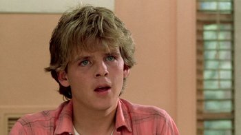 Movie still from “A Nightmare on Elm Street 2: Freddy's Revenge” (1985), directed by Jack Sholder – A young man in a pink shirt looking up; Close Up shot, Low angle