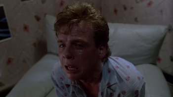 Movie still from “A Nightmare on Elm Street 2: Freddy's Revenge” (1985), directed by Jack Sholder – A person sitting on a bed; Close Up shot, Low angle