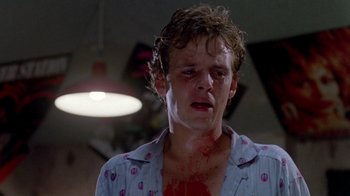Movie still from “A Nightmare on Elm Street 2: Freddy's Revenge” (1985), directed by Jack Sholder – A man with a bloody shirt on his face; Close Up shot, Low angle