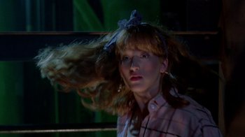 Movie still from “A Nightmare on Elm Street 2: Freddy's Revenge” (1985), directed by Jack Sholder – A woman with a messy hair style in the dark; Close Up shot, Low angle