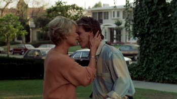 Movie still from “A Nightmare on Elm Street 2: Freddy's Revenge” (1985), directed by Jack Sholder – A man and a woman kissing in front of a house; Medium shot, Low angle