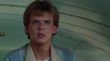 Movie still from “A Nightmare on Elm Street 2: Freddy's Revenge” (1985), directed by Jack Sholder – A young man in a white shirt and a blue sweater; Close Up shot, Over the shoulder angle