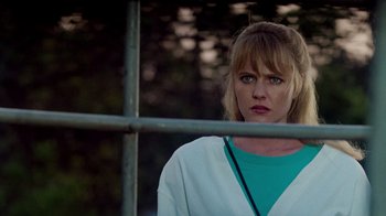 Movie still from “A Nightmare on Elm Street: The Dream Child” (1989), directed by Stephen Hopkins – A woman standing in front of a metal fence; Close Up shot, Low angle
