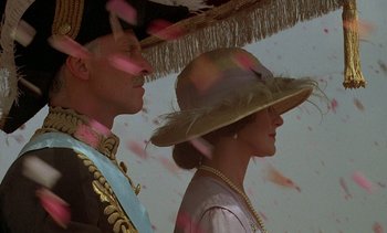 Movie still from “A Passage to India” (1984), directed by David Lean – A man and a woman wearing hats standing next to each other; Close Up shot, Low angle