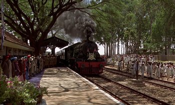 Movie still from “A Passage to India” (1984), directed by David Lean – A steam train is coming down the tracks; Extreme Wide shot, High angle