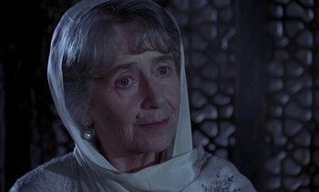Movie still from “A Passage to India” (1984), directed by David Lean – An older woman wearing a white veil looking at the camera; Close Up shot, Over the shoulder angle