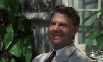 Movie still from “A Passage to India” (1984), directed by David Lean – An older man with a mustache wearing a suit and tie; Close Up shot, Over the shoulder angle