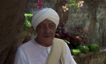Movie still from “A Passage to India” (1984), directed by David Lean – An old man wearing a white turban and a white shirt; Close Up shot, Over the shoulder angle