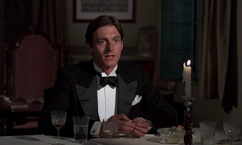 Movie still from “A Passage to India” (1984), directed by David Lean – A man sitting at a dinner table in a tuxedo; Close Up shot, Low angle