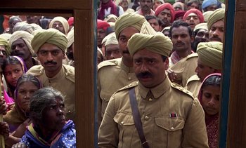 Movie still from “A Passage to India” (1984), directed by David Lean – A group of men in military uniforms standing next to each other; Medium shot, High angle