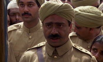 Movie still from “A Passage to India” (1984), directed by David Lean – A group of men in military uniforms are standing together; Close Up shot, High angle