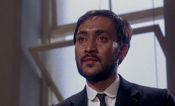 Movie still from “A Passage to India” (1984), directed by David Lean – A person wearing a suit and tie; Close Up shot, Low angle