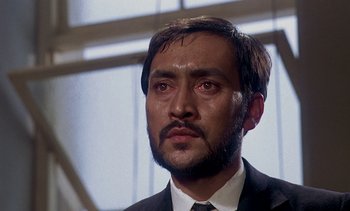 Movie still from “A Passage to India” (1984), directed by David Lean – A person wearing a suit and tie; Close Up shot, Low angle