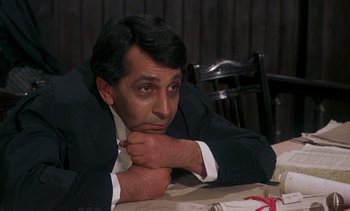 Movie still from “A Passage to India” (1984), directed by David Lean – A man sitting at a table with his hand under his chin; Close Up shot, High angle