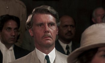 Movie still from “A Passage to India” (1984), directed by David Lean – A man in a suit and a tie; Close Up shot, Over the shoulder angle