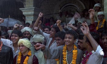Movie still from “A Passage to India” (1984), directed by David Lean – A group of people with yellow flowers in their hair; Wide shot, High angle
