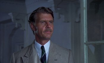 Movie still from “A Passage to India” (1984), directed by David Lean – A person wearing a suit and a tie; Close Up shot, Low angle